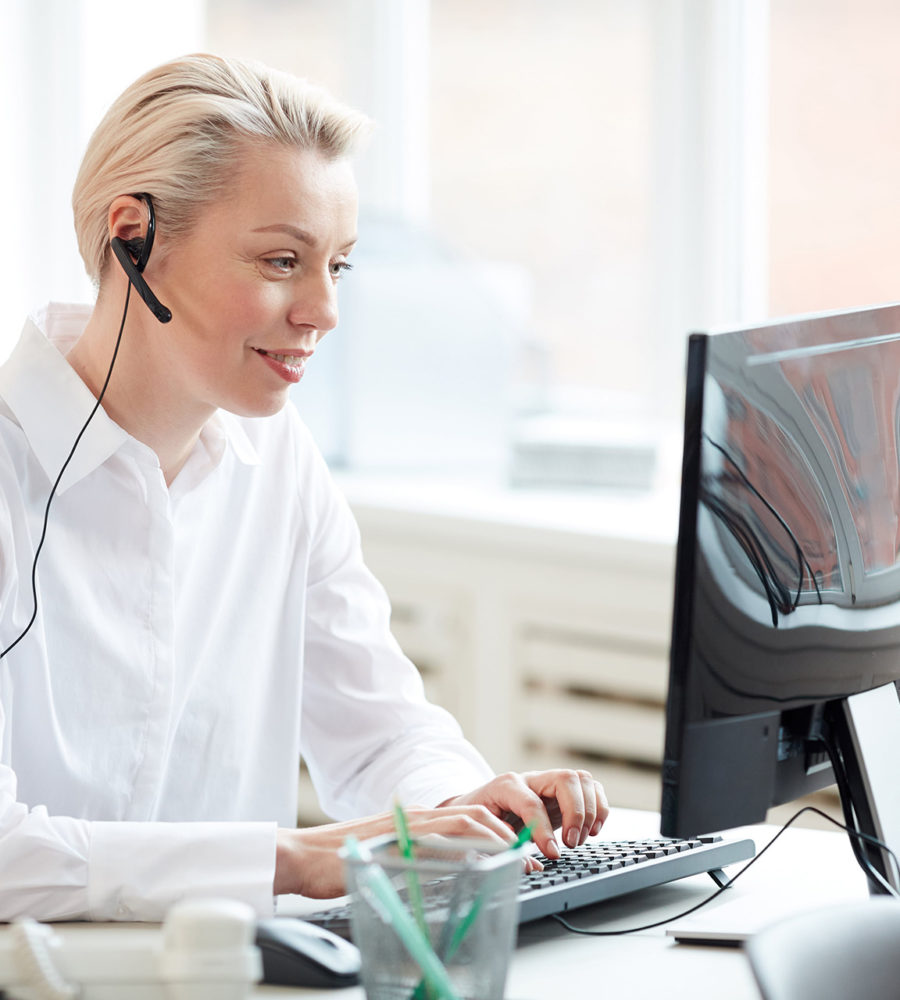 Telefonische MPU-Beratung durch eine Frau mit Headset vor einem Computerbildschirm